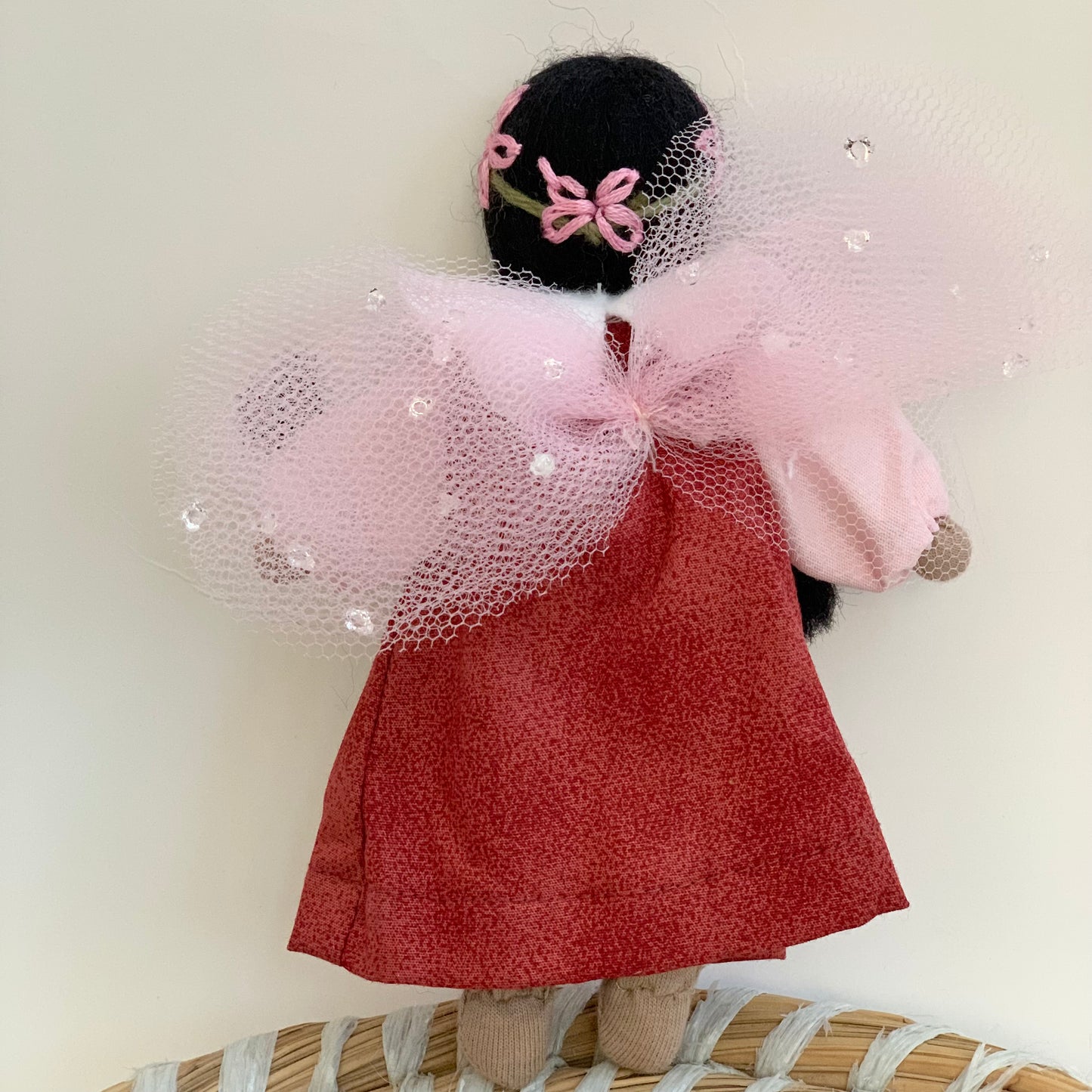 back of evi waldorf garden fairy doll with black hair and pink wings