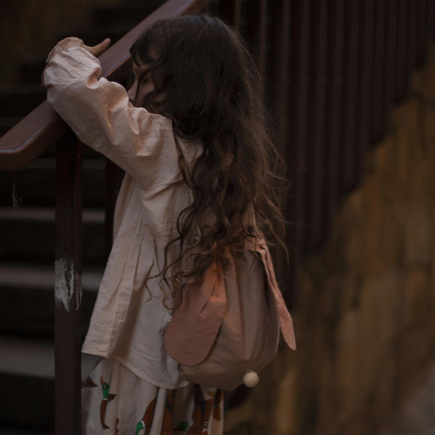 Girl wearing floppy ear bunny rabbit backpack