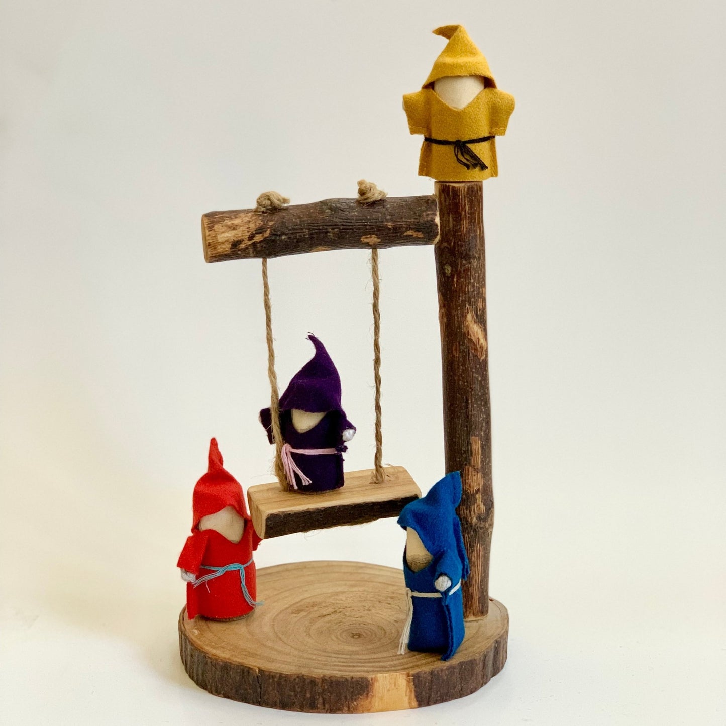 treehouse gnome dolls on a wooden swing