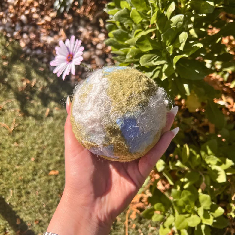 Hand holding a handmade felted ball made using a filges needle felting starter set