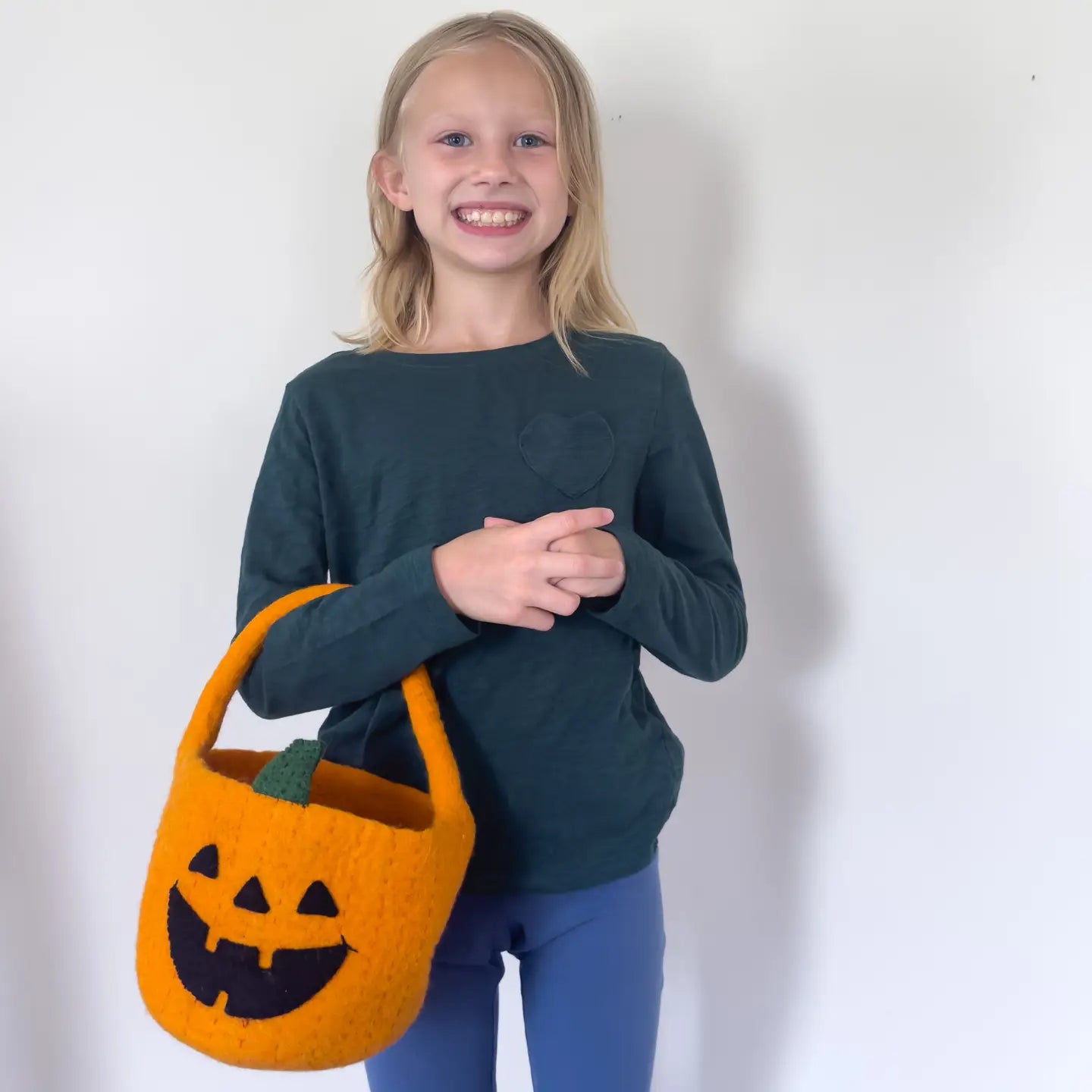 girl holding handmade felt pupmpkin jack-o-lantern trick or treat basket