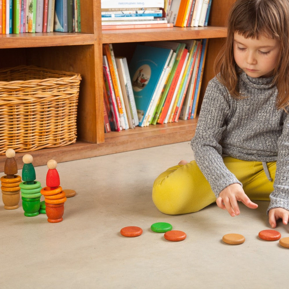 Girl stacking Grapat Autumn colored wooden nins, rings and cups