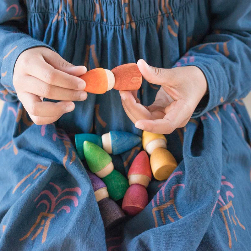 girl playing with grapat wooden nins rainbow tomtens