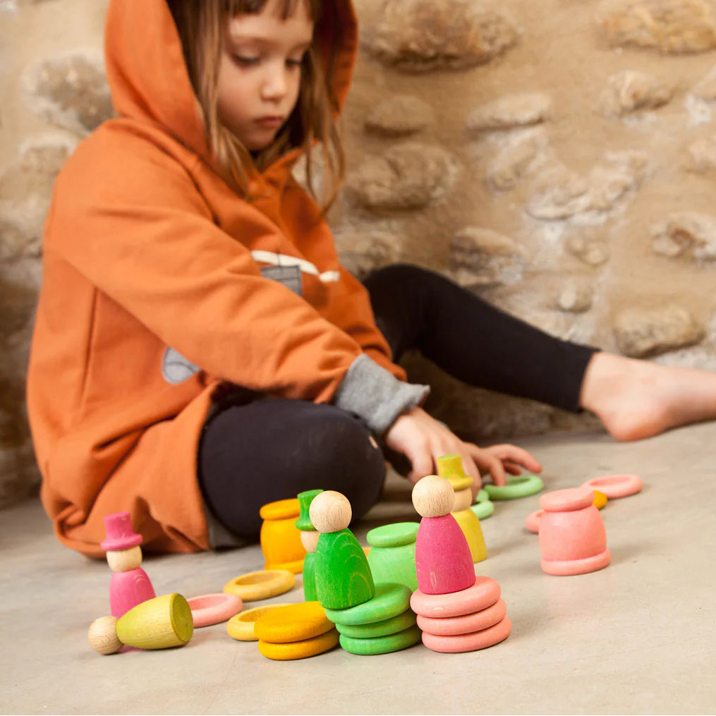 girl playing with grapat aguamarina wooden spring nins, cups, rings and coins play set
