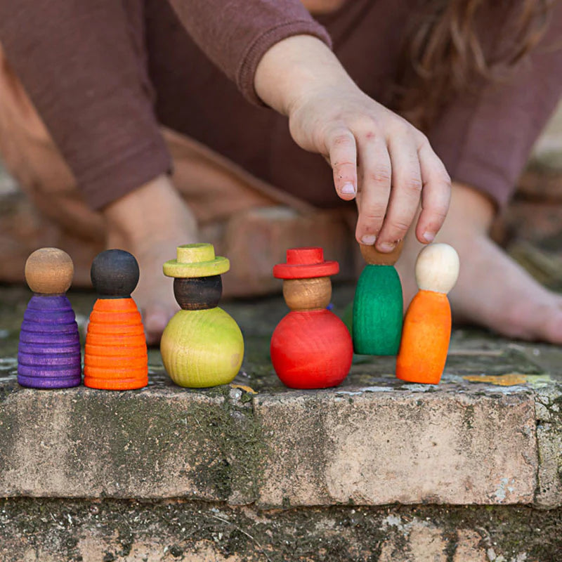 kid playing with grapat wooden peg doll nins diverse together set