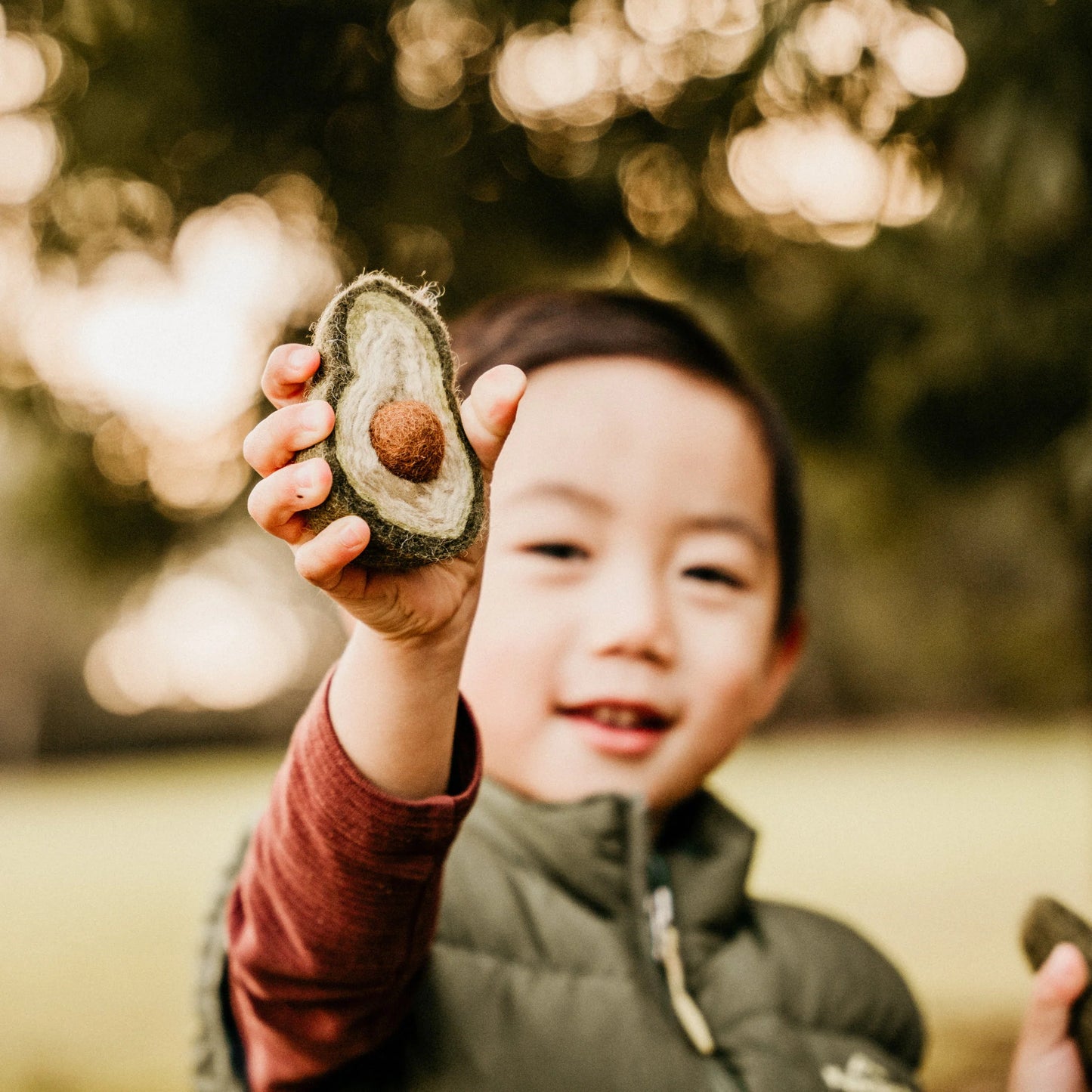 boy with eco-friendly felted play food avocado