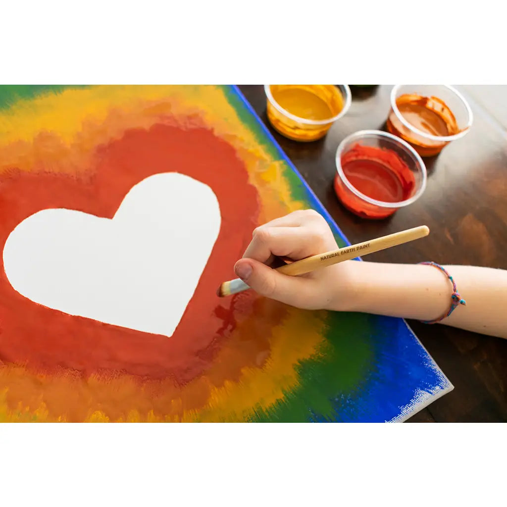 Hand painting a vibrant rainbow heart with Natural Earth paints