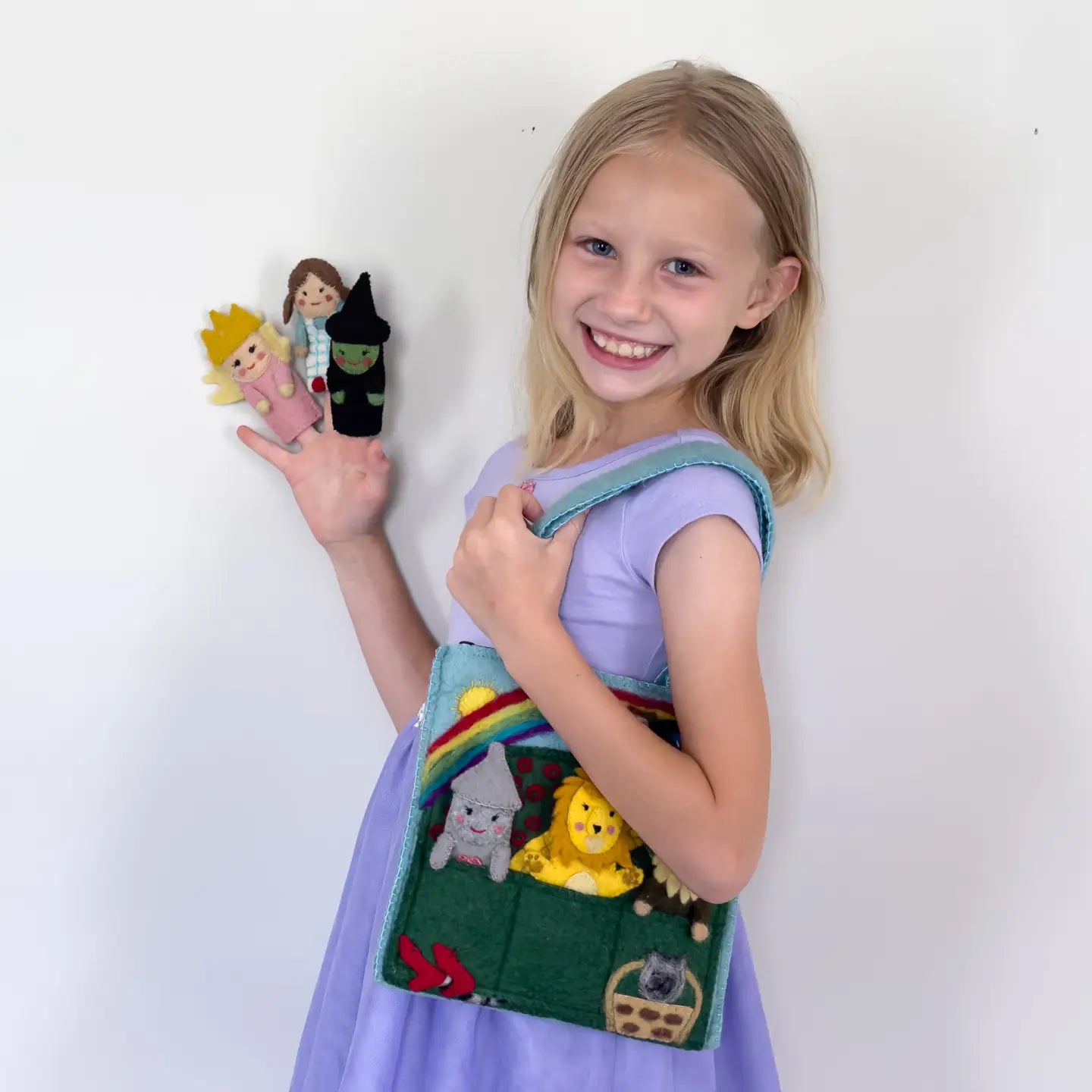 girl holding handmade felt wizard of oz puppet bag play set