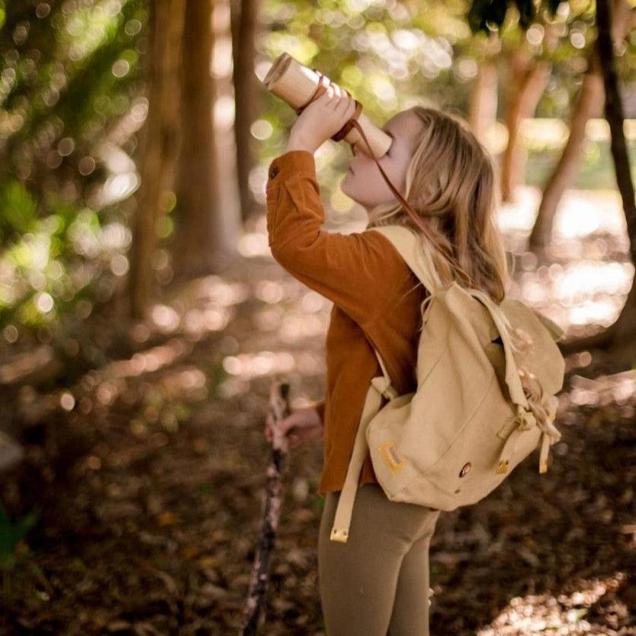 girl with wooden toy binoculars