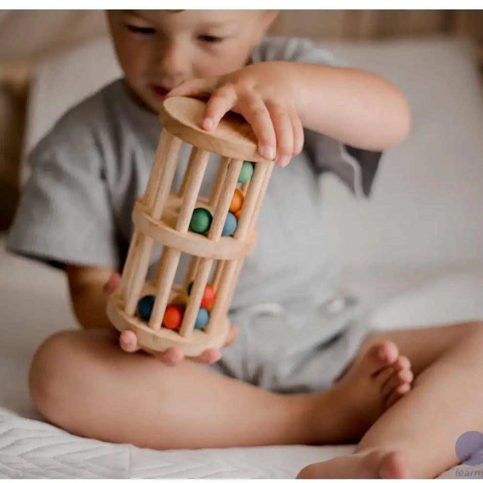 baby holding qtoys natural mini wooden rainmaker toy