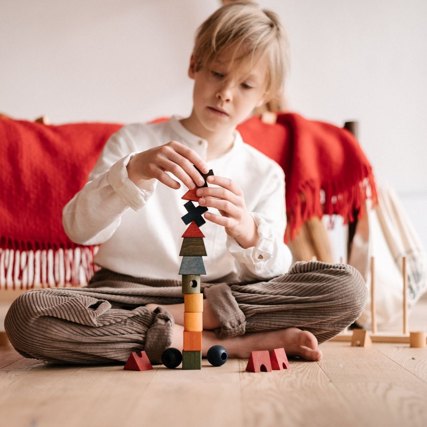 boy stacking wooden rainbow shapes
