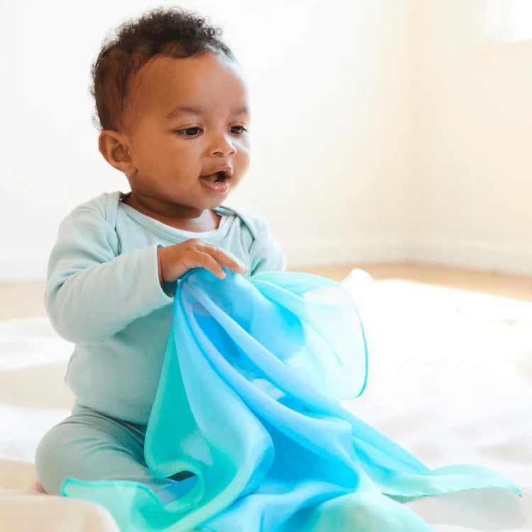 baby playing with sarah's silks mini sea playsilk