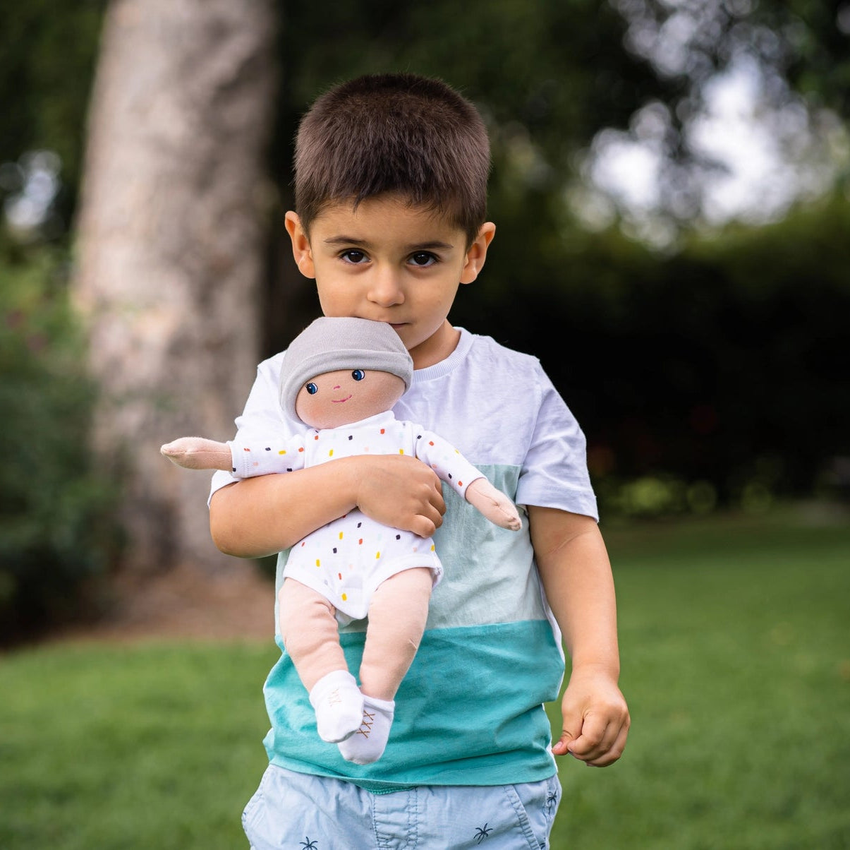 boy playing with tikiri toys bonikka gender neutral cotton doll