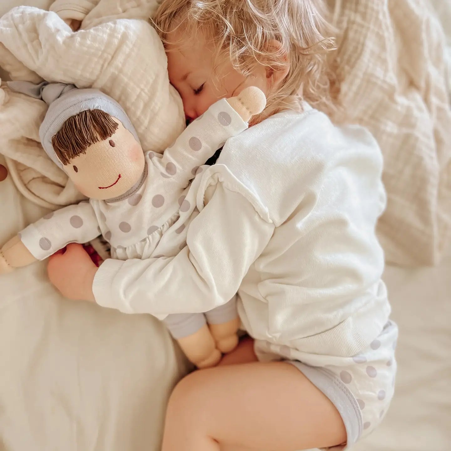 toddler girl holding under the nile waldorf doll