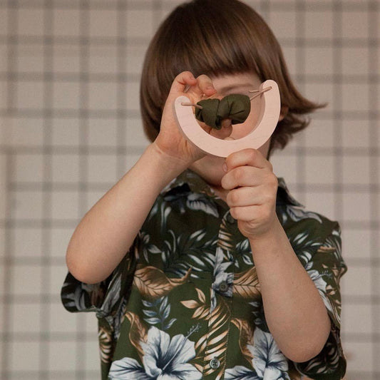 Kid playing with wooden slingshot toy