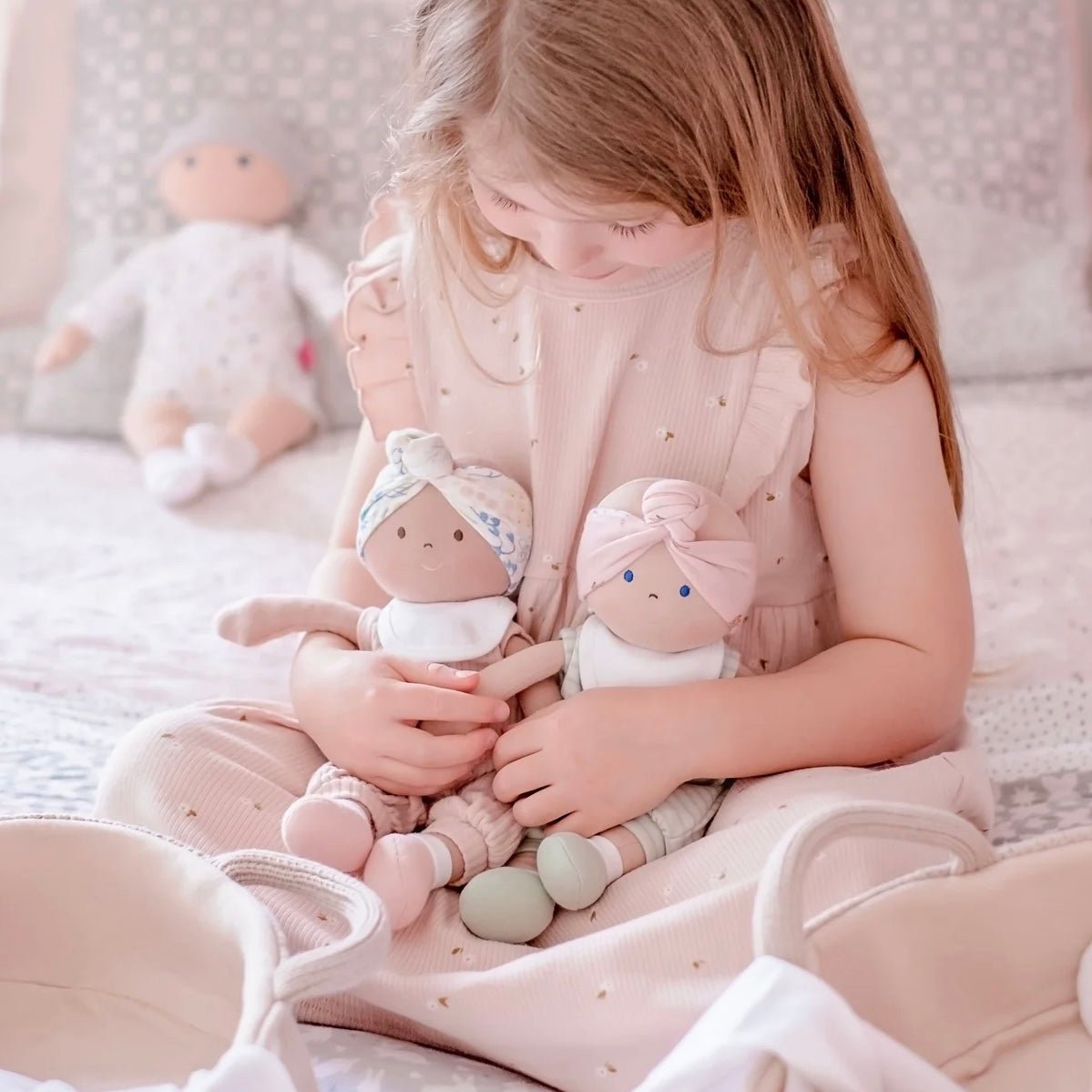 Girl holding light and dark skin dolls