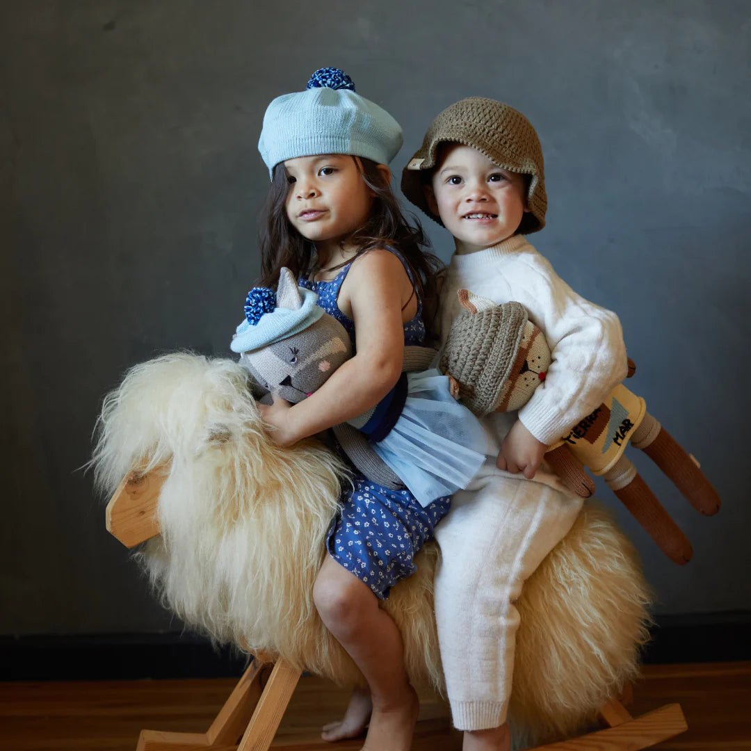 Girl and boy holding handmade plush dogs