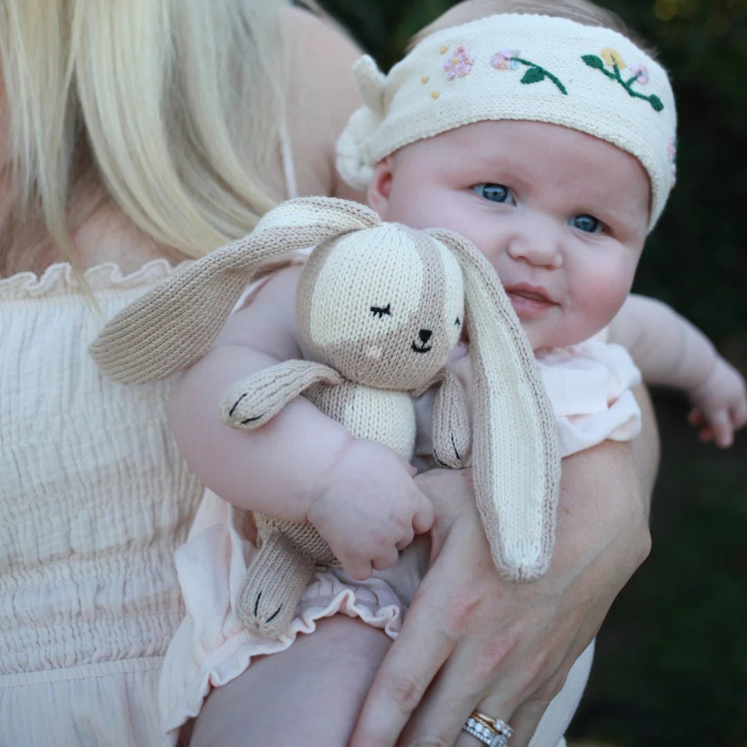 baby with red and olive plush bunny rabbit doll