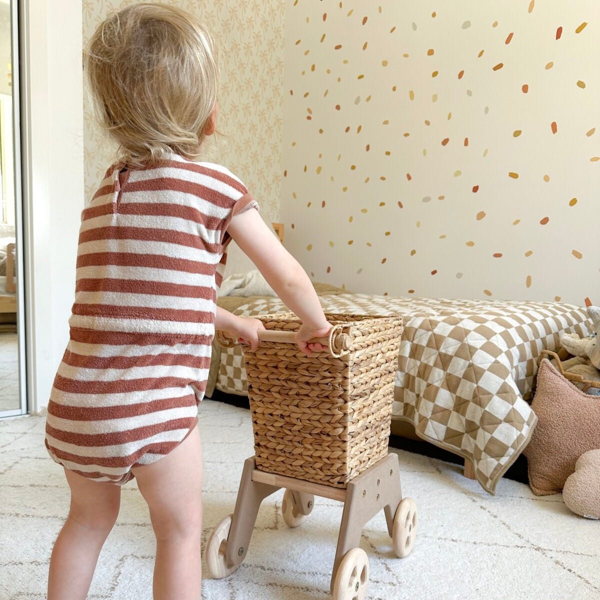 Girl playing with wicker shopping cart