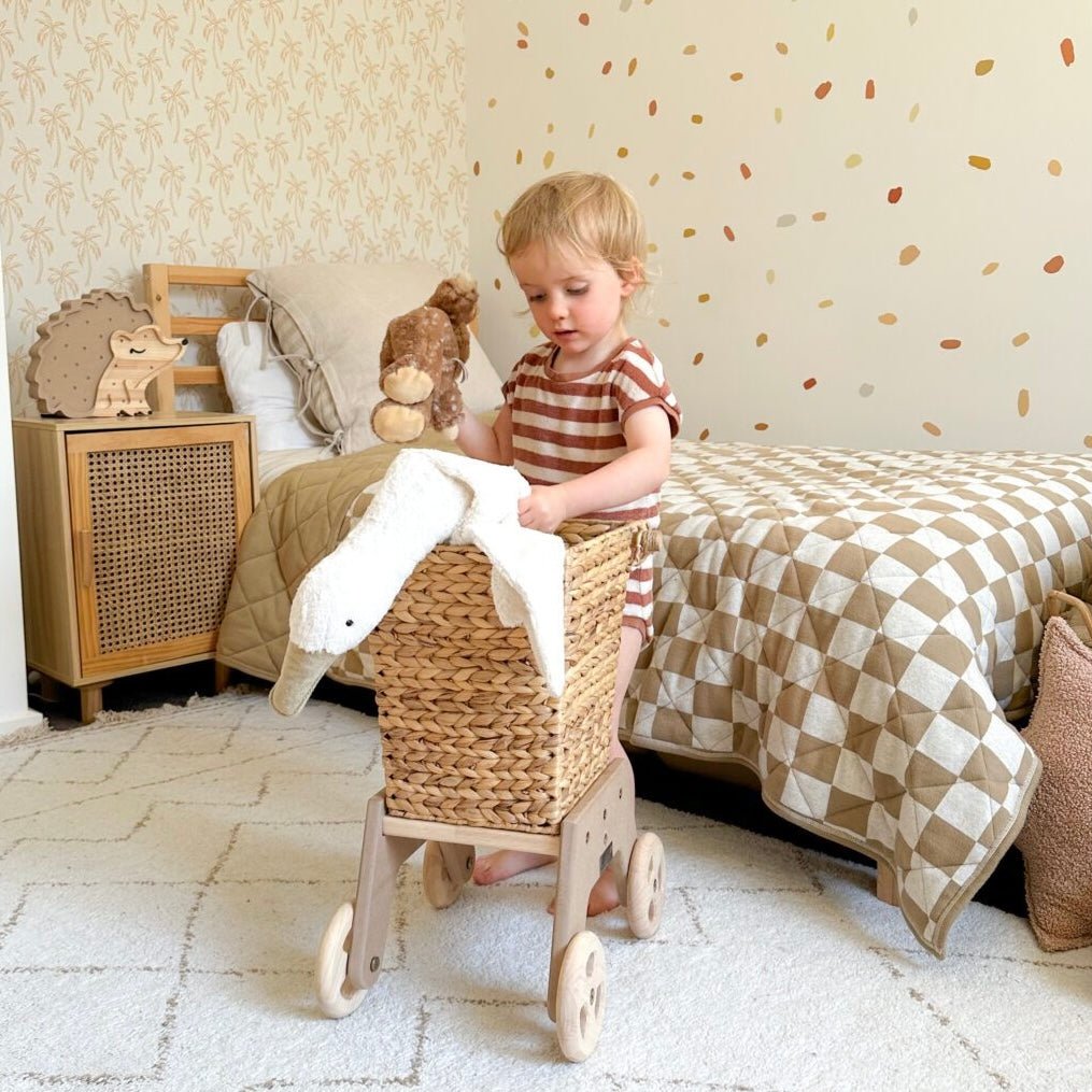 Girl playing with natural wicker shopping cart