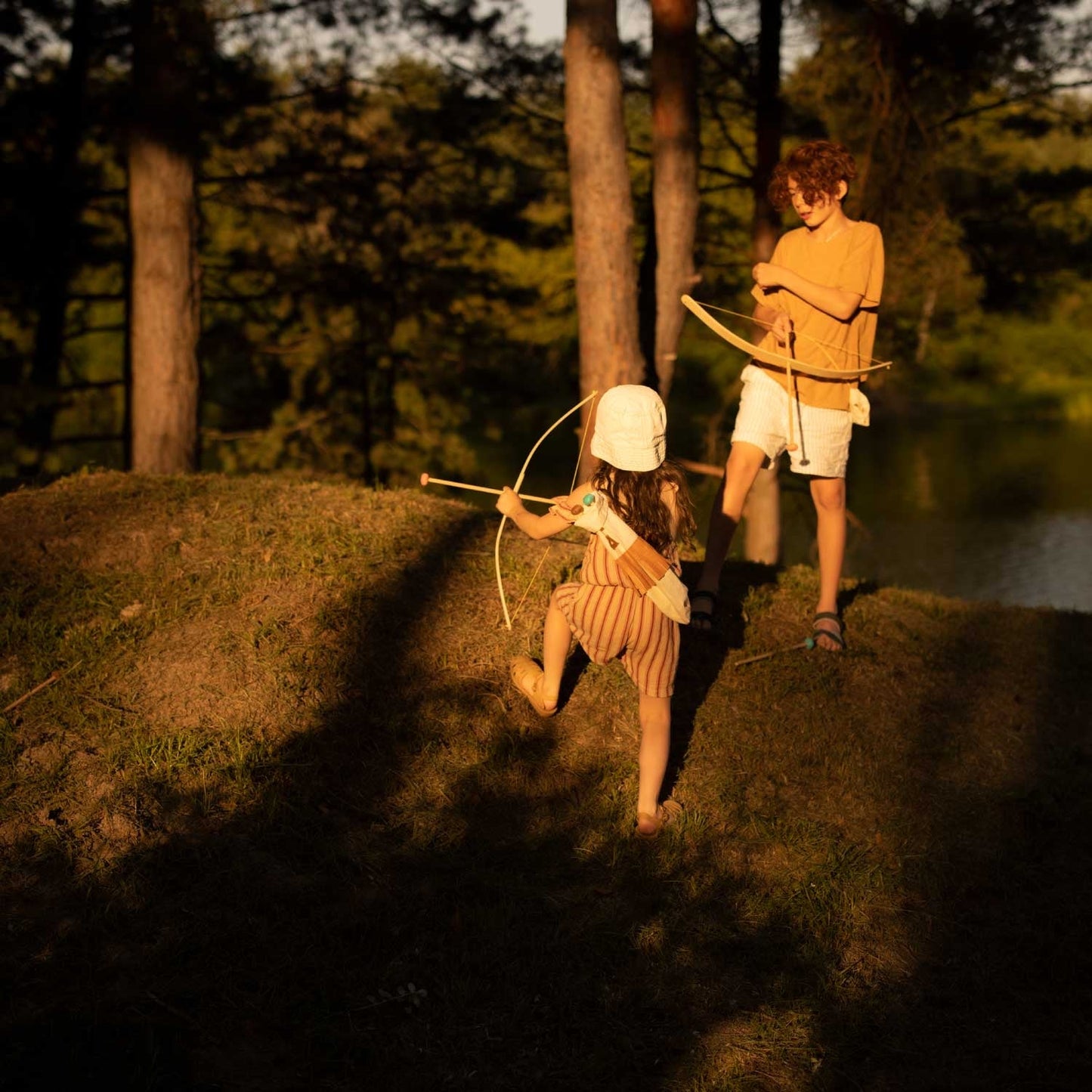 girl and boy playing pretend archery