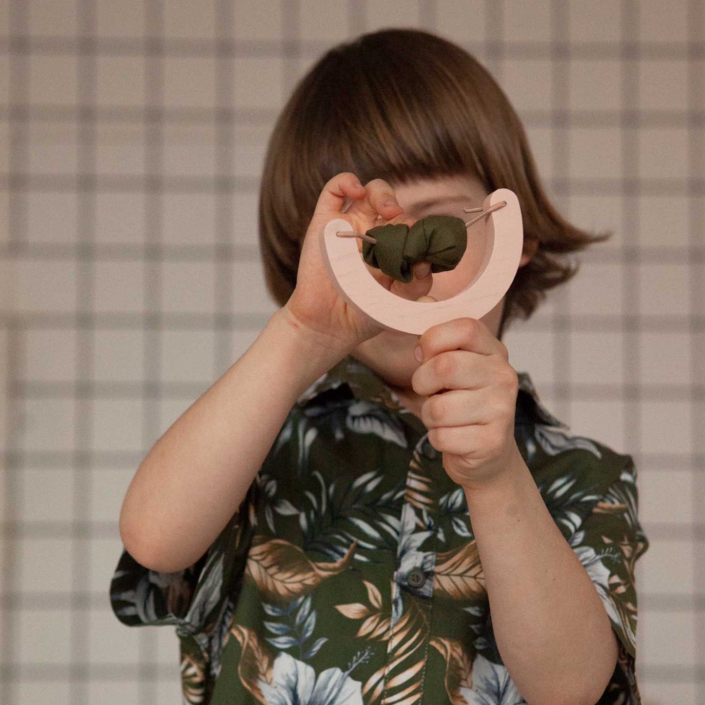 boy with wooden slingshot toy