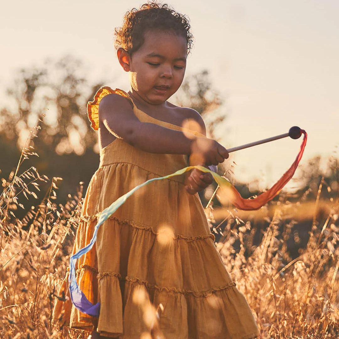 Girl playing with Sarah's silks mini rainbow streamer wand