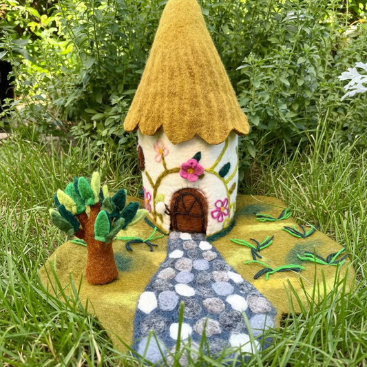 Felted cottage dollhouse with a stone path and a finger puppet tree