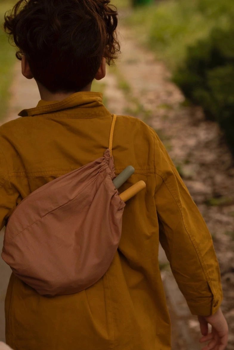 boy carrying badminton set in backpack