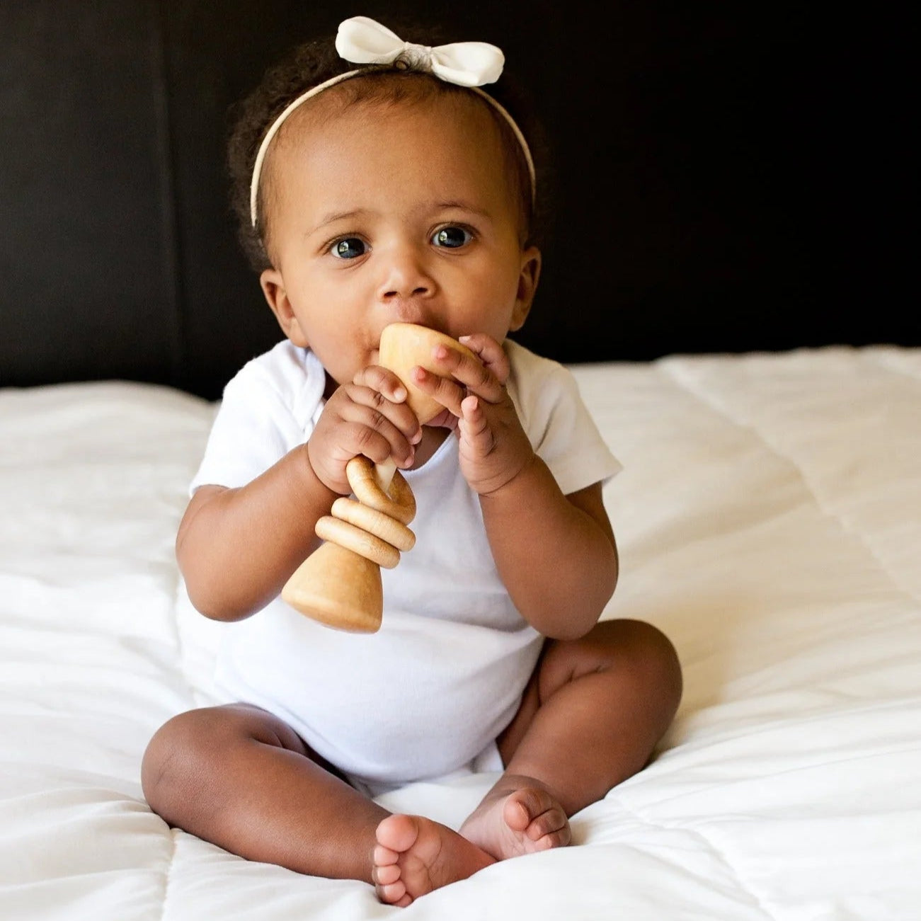 baby with organic wooden classic toy rattle