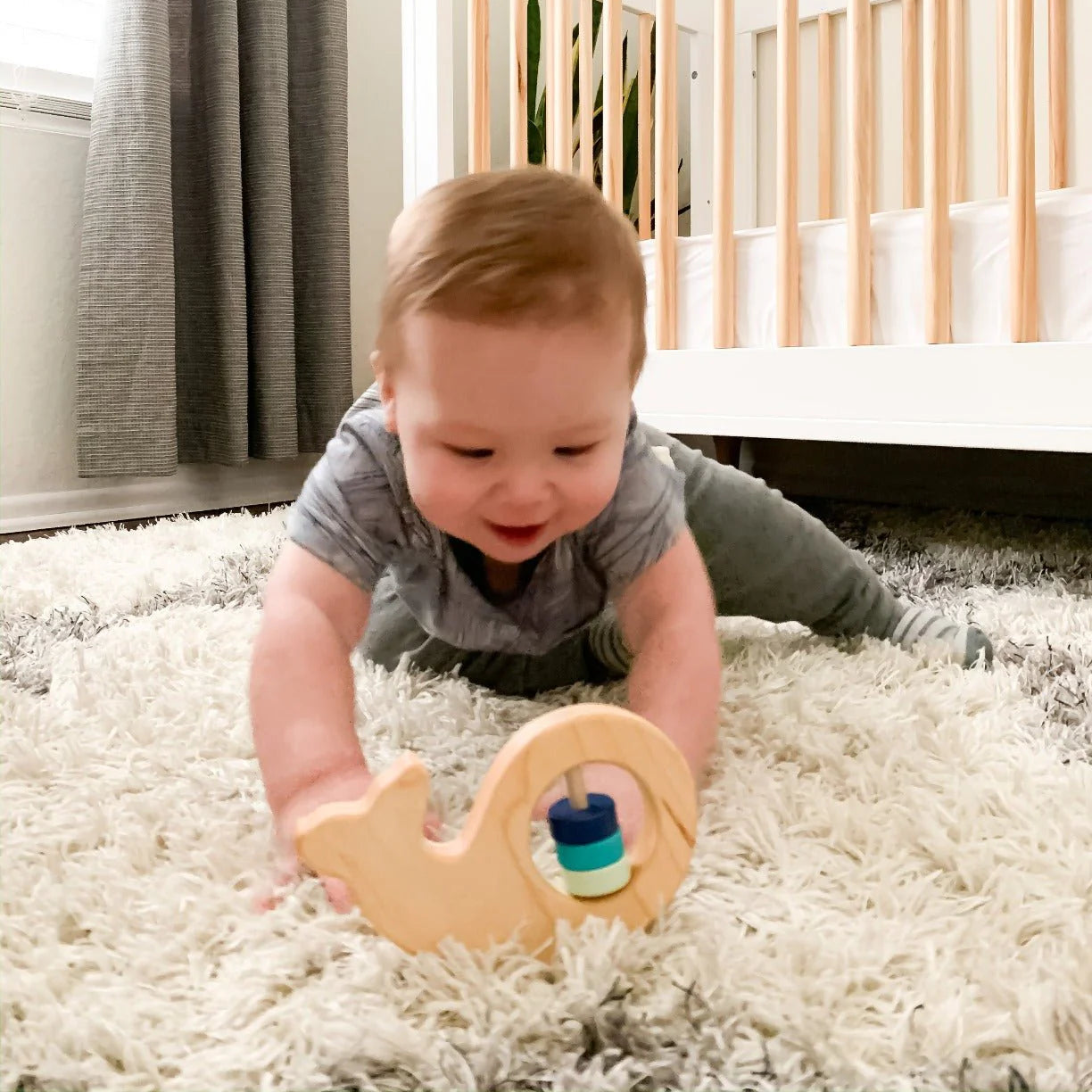 baby with organic wooden whale baby rattle from bannor toys