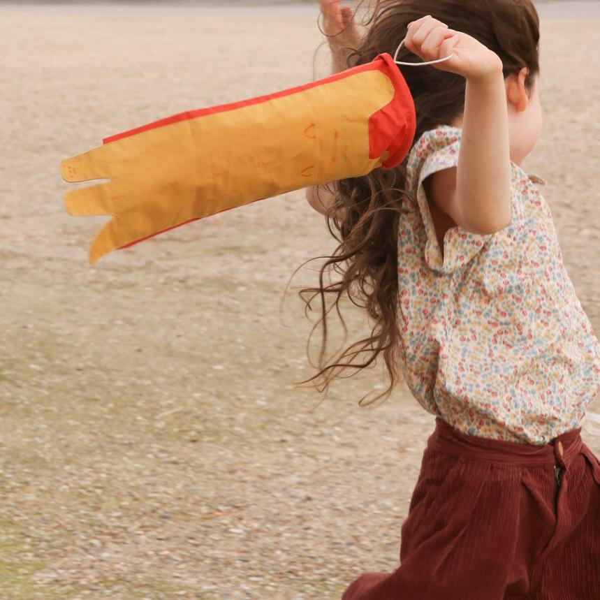 girl running with cat wind catcher toy