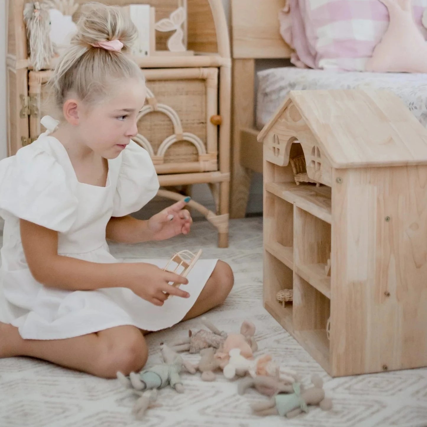 girl playing with classic wooden dollhouse