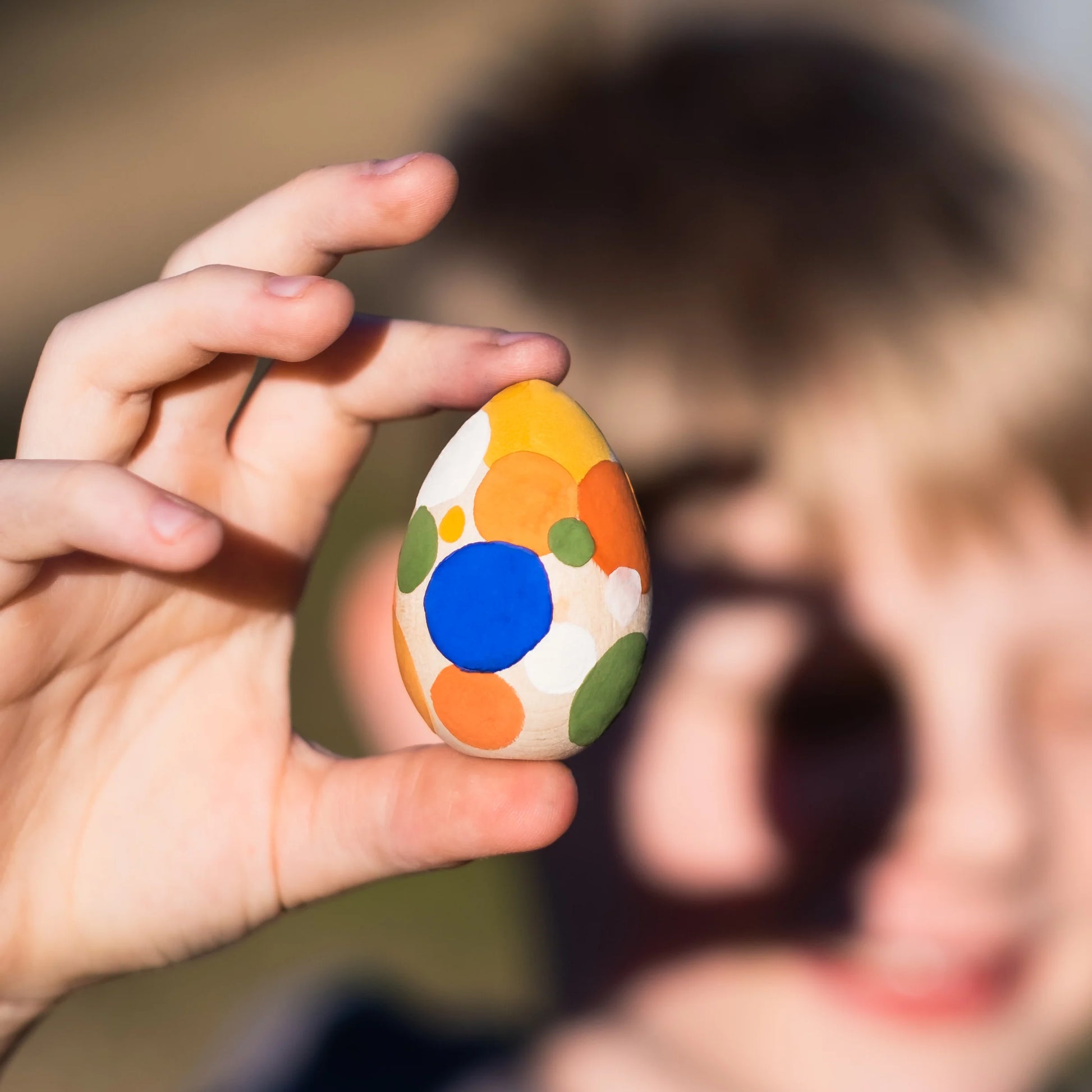Boy holding his painted  wooden Easter egg
