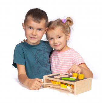 Two children playing with Erzi Wooden Raclette Grill set with pans and play food.