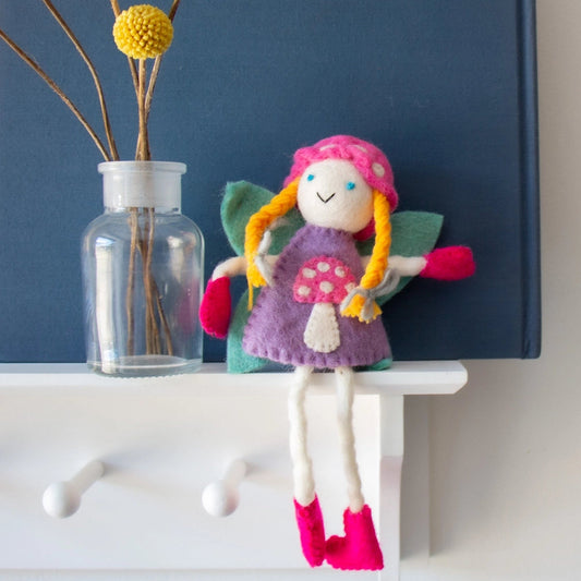 Colorful tooth fairy doll with blonde hair and a purple mushroom dresss