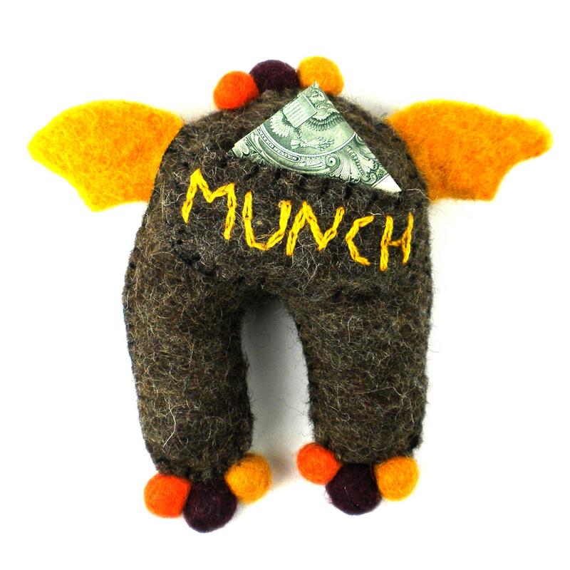 Felted monster tooth fairy pillow with 'MUNCH' and a dollar bill in his pocket