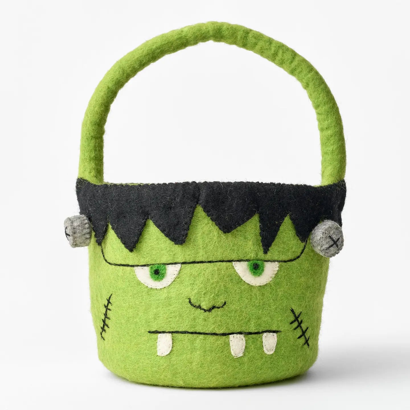 A felt Frankenstein monster Halloween candy bucket featuring a black stitched hair, embroidered eyes, mouth, and teeth.