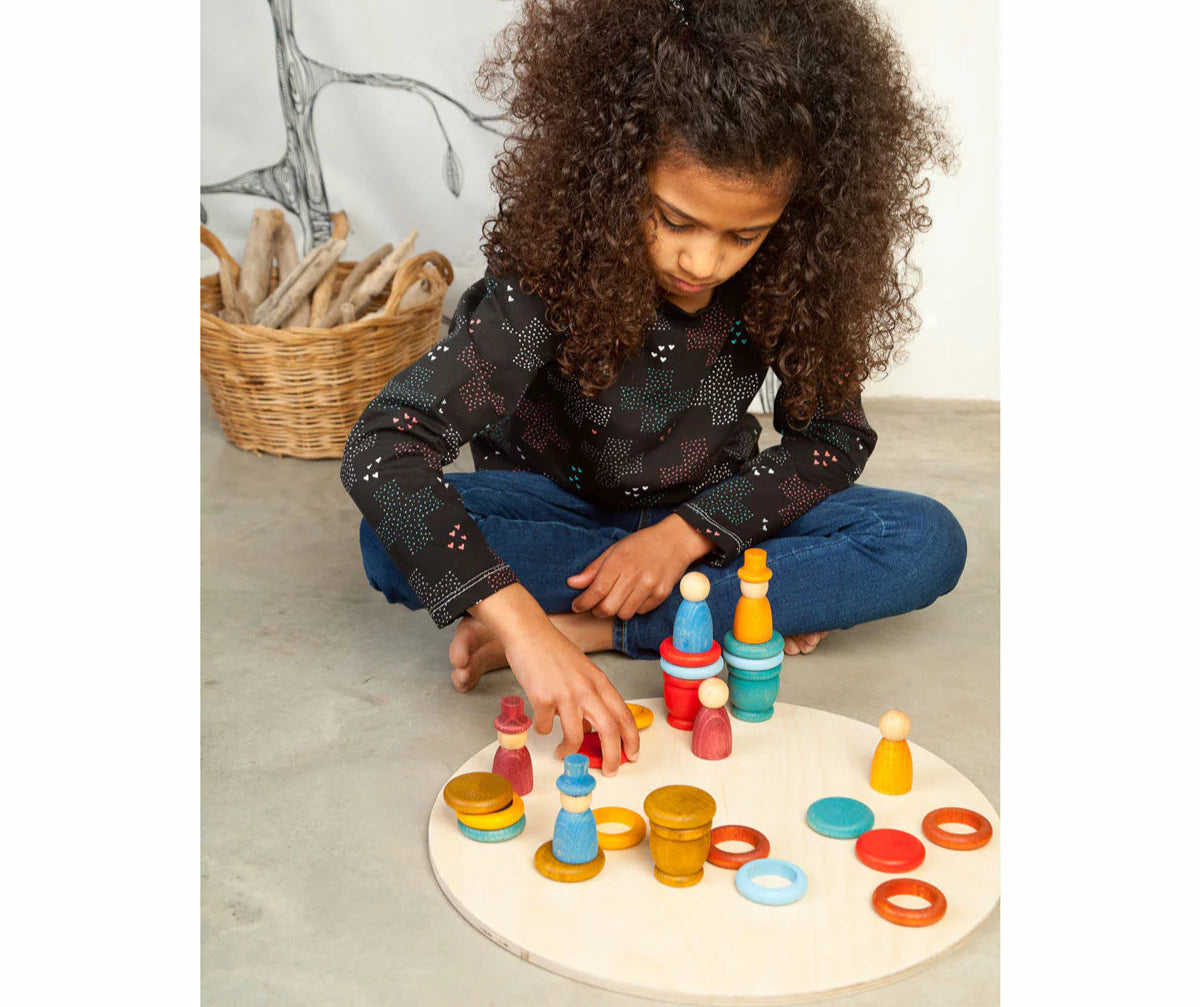 girl with grapat aguamarina summer wooden loose parts toys, nins, cups, coins, and rings