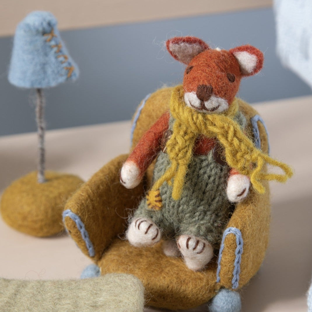 felt miniature fox doll in scarf sitting on a dollhouse chair