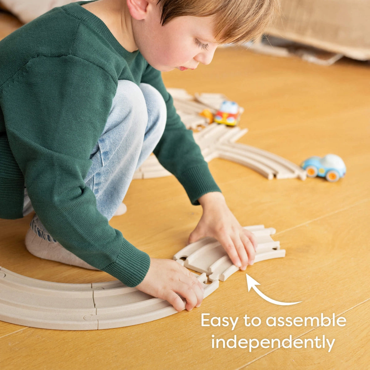 Boy putting together his Haba cars wooden racetrack