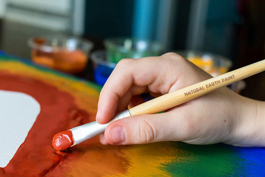 Boy holding a natural earth bamboo paintbrush