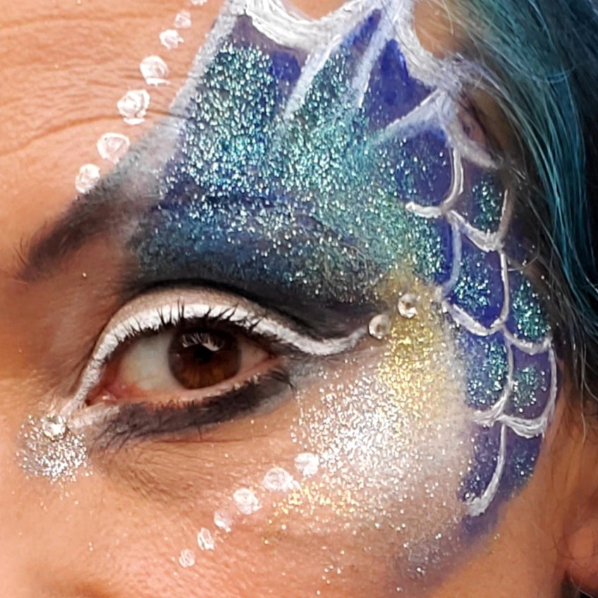 Close-up of a person with mermaid-themed makeup, example of natural earth face paint glitter