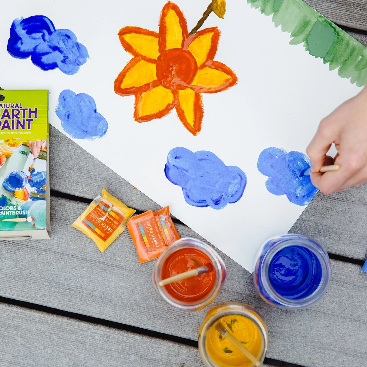 Child painting with Natural Earth Paint kit with colorful paint samples