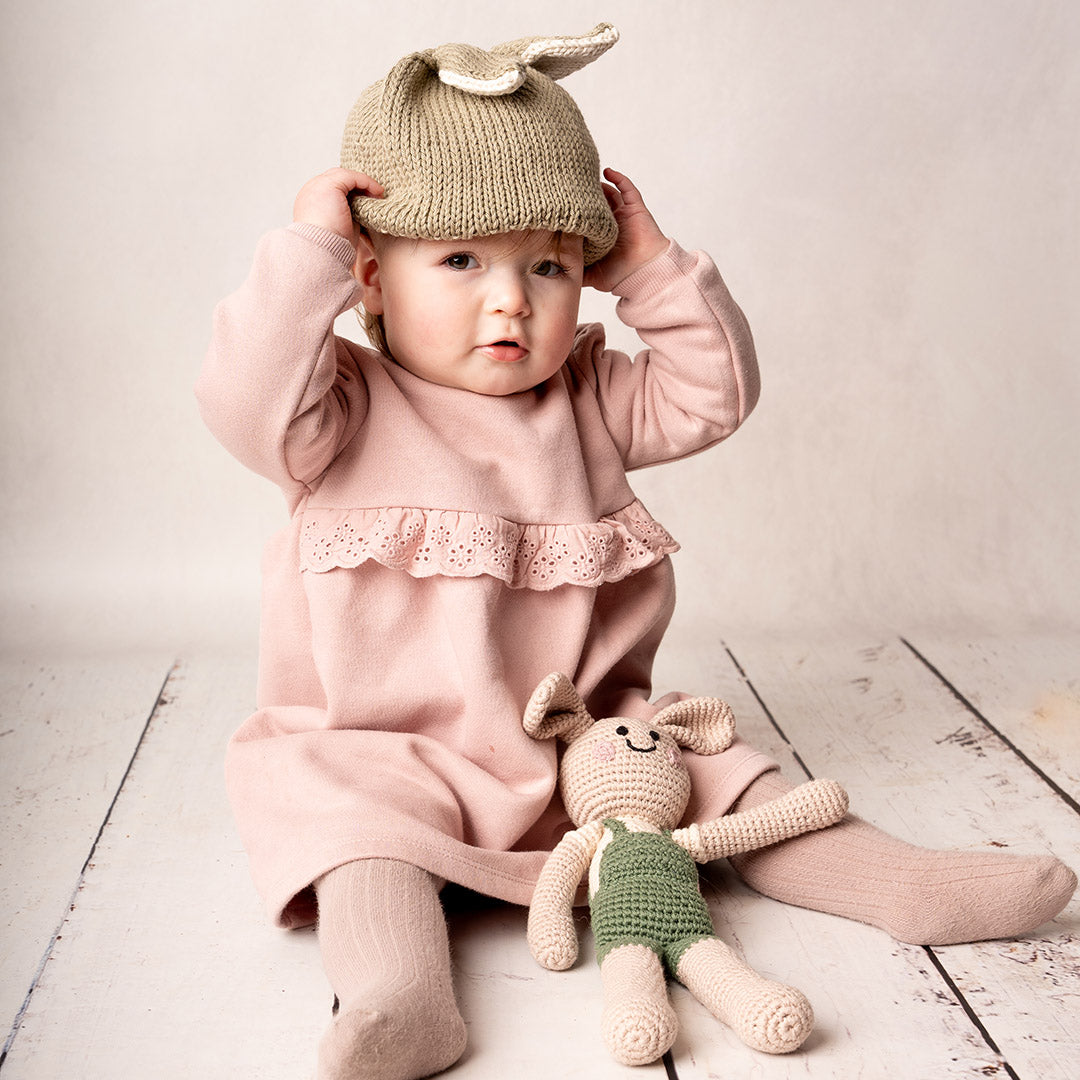 Baby girl wearing organic hand knit bunny ear beanie