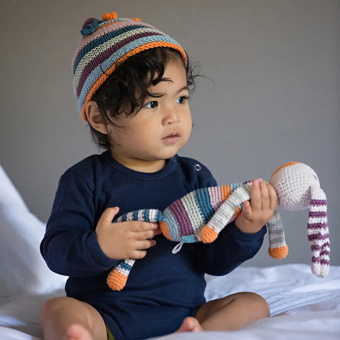 baby holding pebble's fair trade organic rainbow bunny