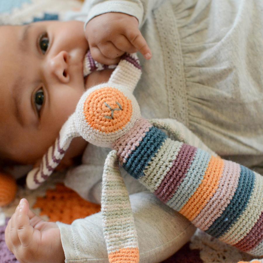 baby with pebble crochet bunny rattle