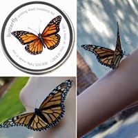 tin of butterfly garden seed with monarch butterflies landing on a child's arm. 