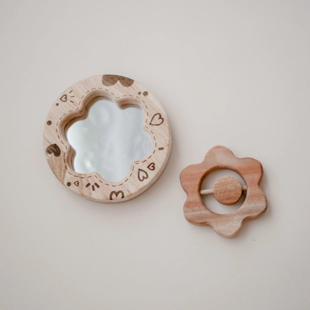 wooden baby toy gift set, flower rattle and heart mirror on a light beige background