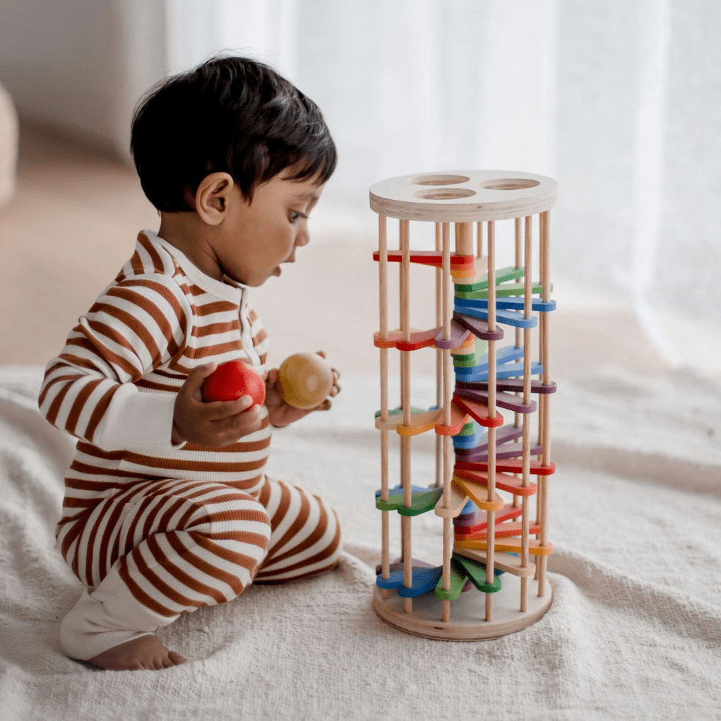 toddler playing with wooden rainbow pound a ball tower